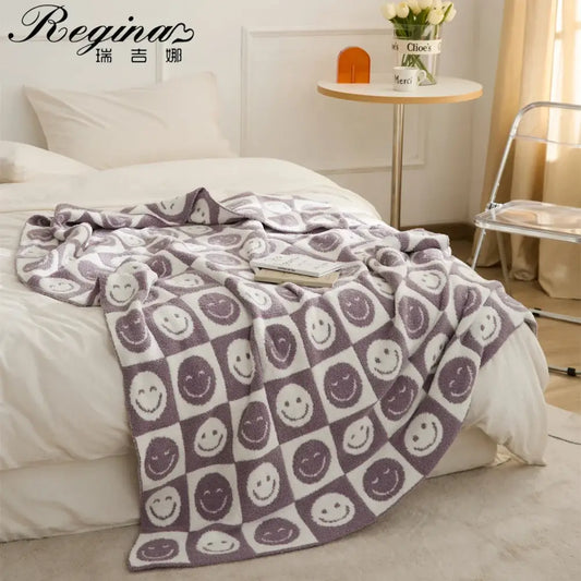A cozy gray and white knitted checkboard smile face blanket with playful smiling designs for bedroom decorbites throw