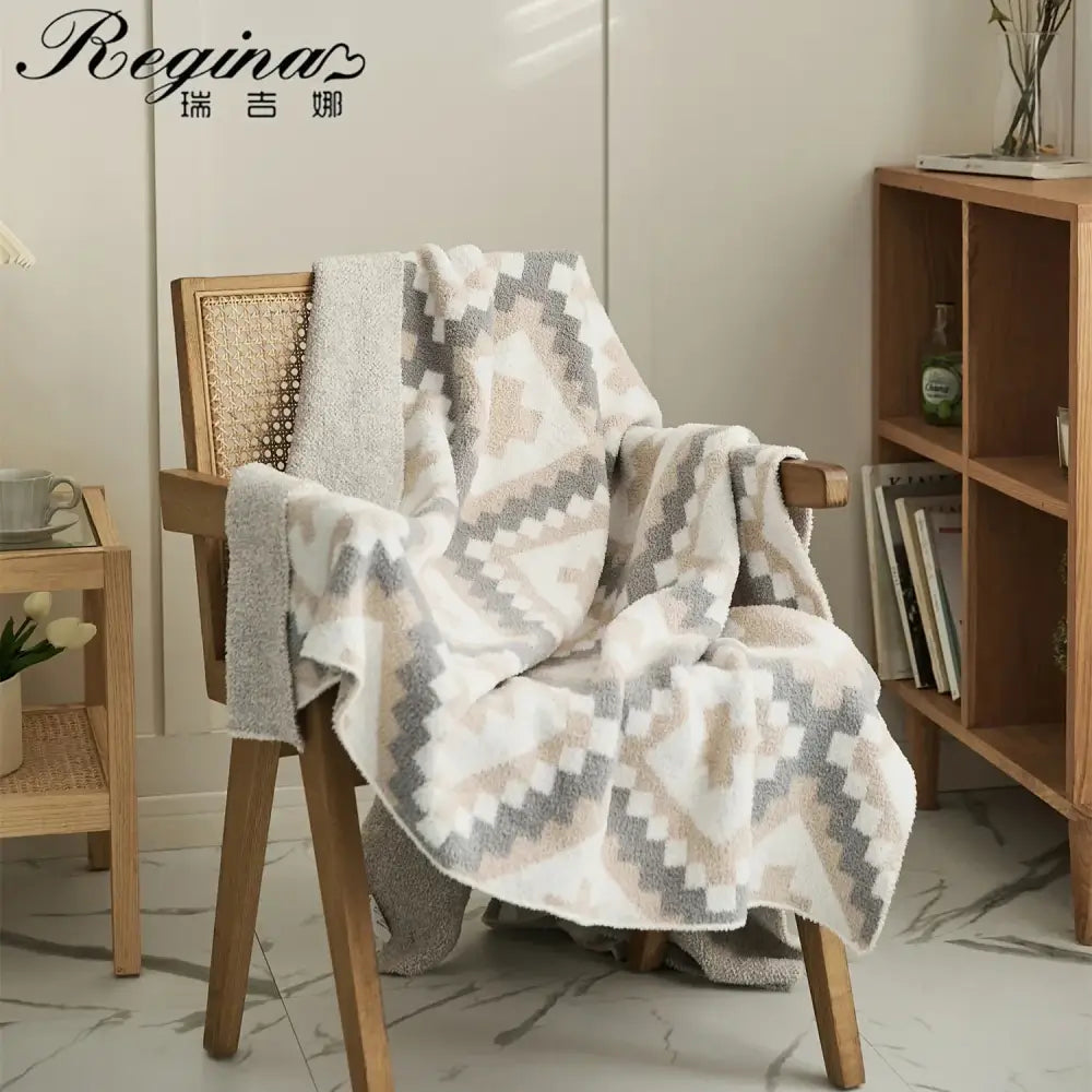 Soft cream and gray knitted geometric quilt blanket terry cloth throw draped on wooden chair for living room decorbites