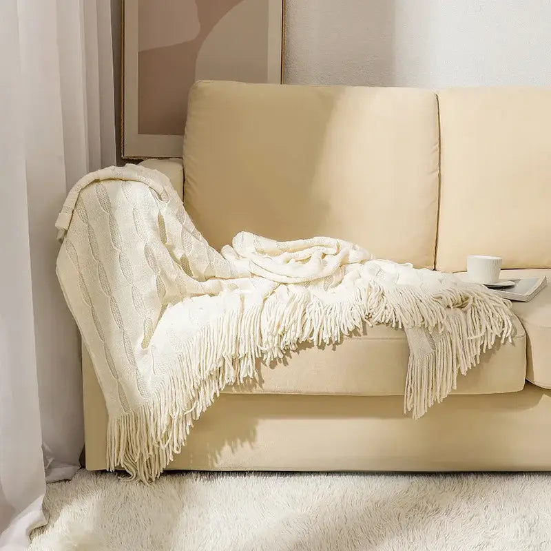 Cream-colored decorbites knitted geometric throw blanket with cable-knit texture and soft long fringe for bedroom decor