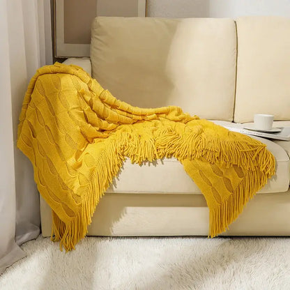 A vibrant yellow decorbites knitted geometric throw blanket with textured cable pattern and soft fringe for bedroom decor