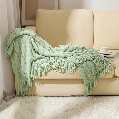 A soft mint green decorbites knitted geometric throw blanket with cable knit pattern and long fringe for bedroom decor
