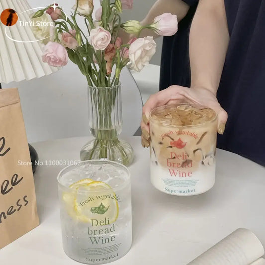 A clear korean glass cup with frosted white lower half and fresh deli graphics filled with ice and lemon slice