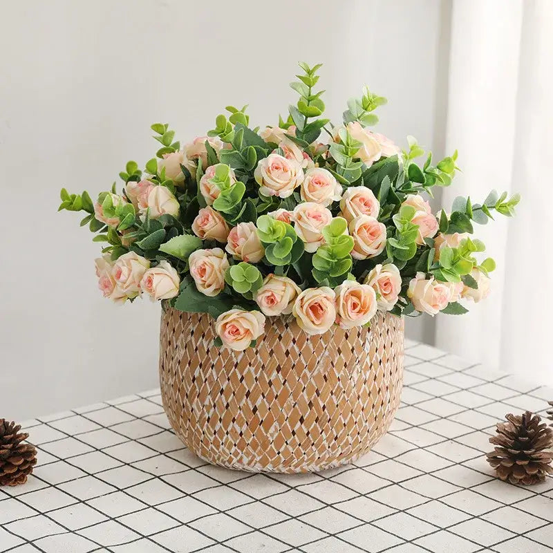 A woven beige basket with a korean style pink and white artificial roses bouquet for home decor