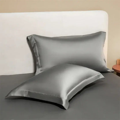 Two sleek metallic gray egyptian cotton pillowcases with a smooth lustrous finish from a cotton pillowcase set