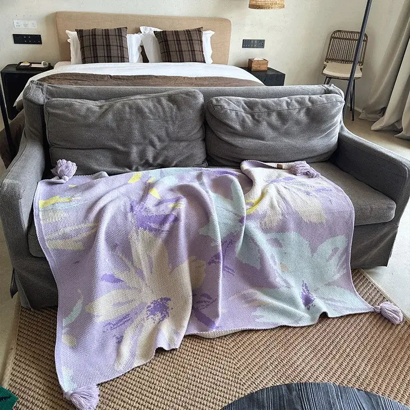 A soft lavender and cream floral decorbites cozy knit blanket with tassels perfect as a living room throw