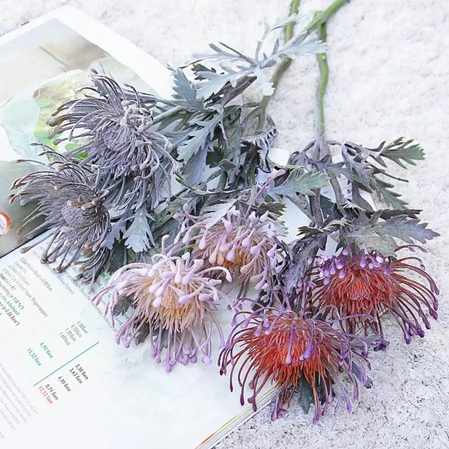 A cluster of gray lavender and deep red artificial protea flowers with green stems for decorbites artificial crab claw branch decor