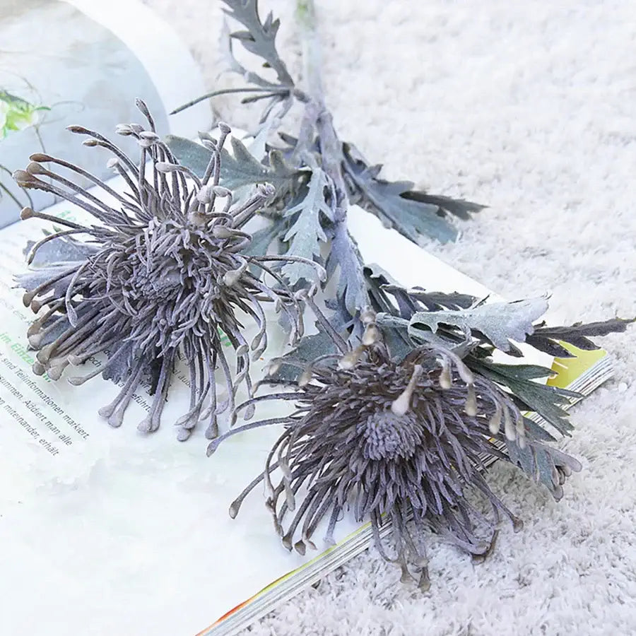 Lavender and orange decorbites artificial crab claw branch featuring frosty gray artificial protea flowers with serrated leaves