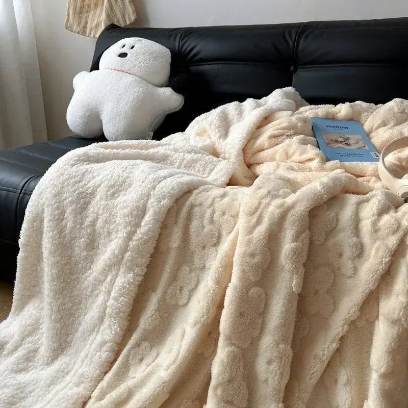 Cream-colored plush throw blanket with soft textured surface and raised floral patterns made of cozy lamb wool flower