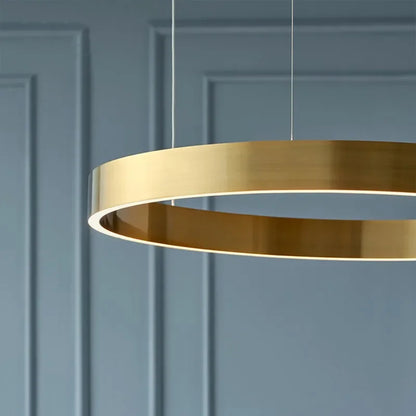 A sleek modern braided gold led chandelier light with circular rings for dining room or kitchen use