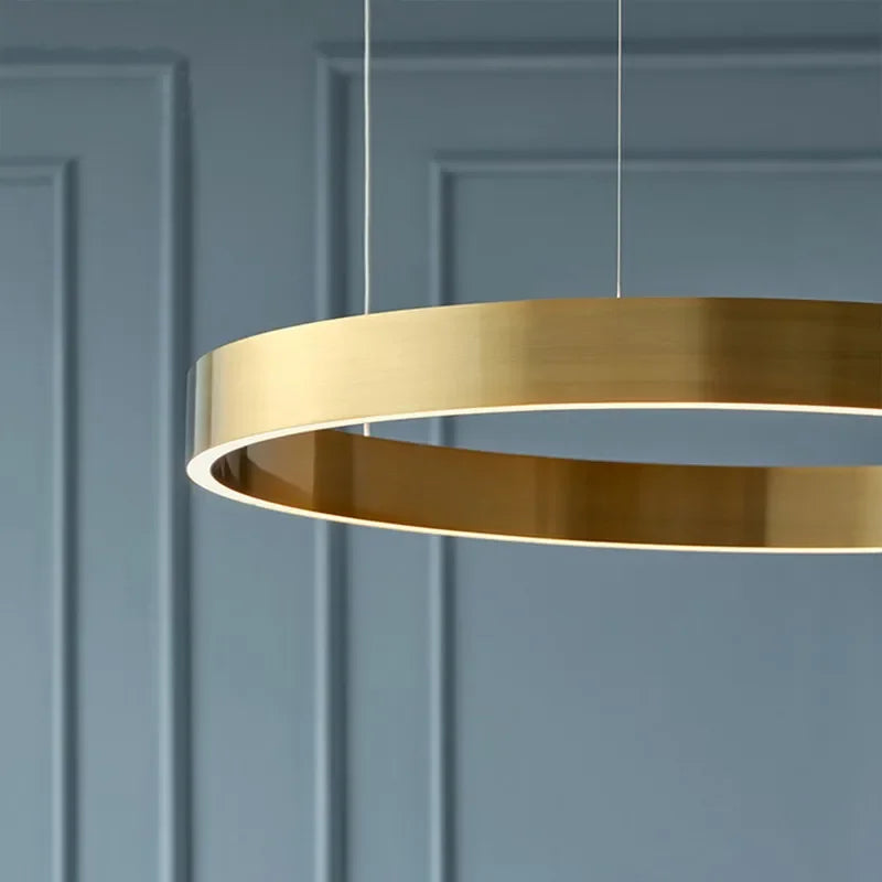 A sleek modern braided gold led chandelier light with circular rings for dining room or kitchen use