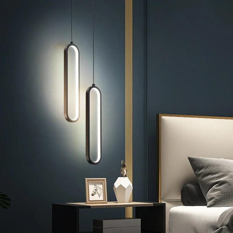 Two black gold led pendant lights with elongated oval shapes and glowing white strips for indoor decor lighting