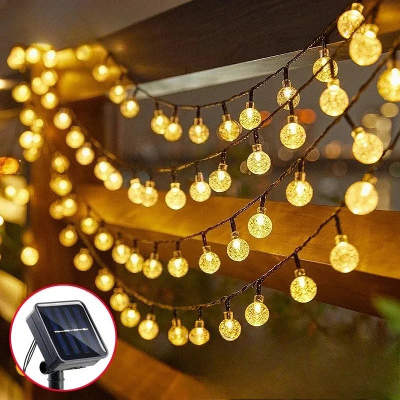 String lights featuring warm white solar crystal globe bulbs with crackled glass and black wiring for outdoor use