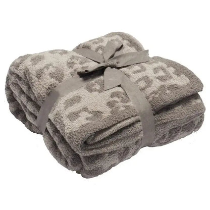 A taupe fleece blanket with subtle leopard print tied with satin ribbon from decorbites leopard print collection