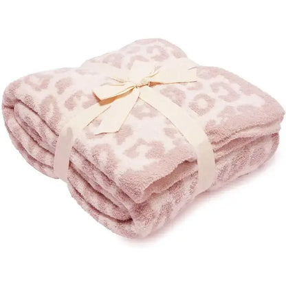 A soft pink leopard print fleece blanket tied with a cream satin ribbon decorbites leopard print throw