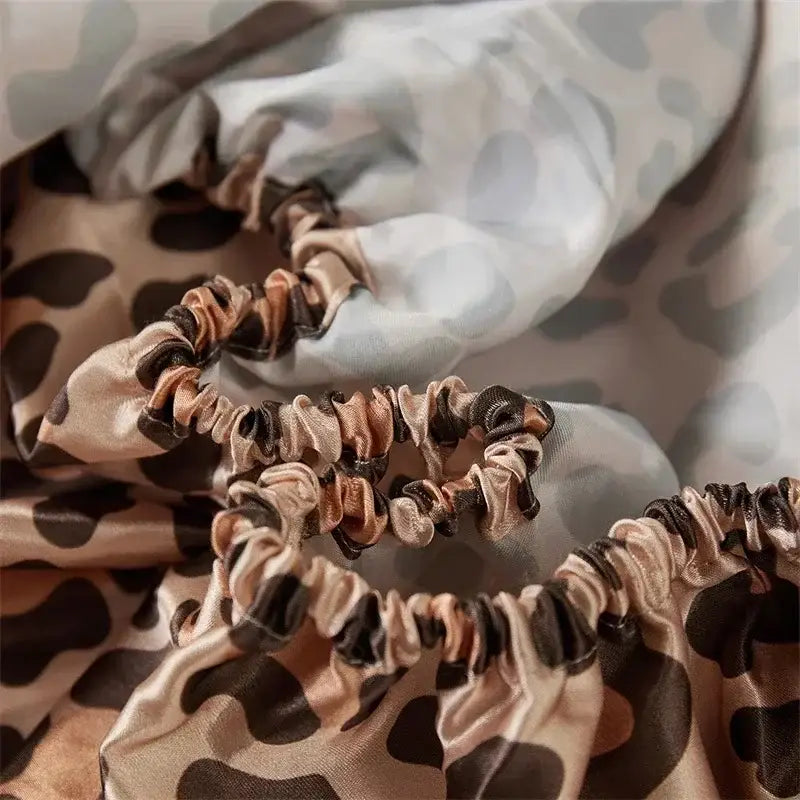 Beige and black leopard print satin scrunchies complementing leopard print satin bedsheet set in beige and brown bedroom