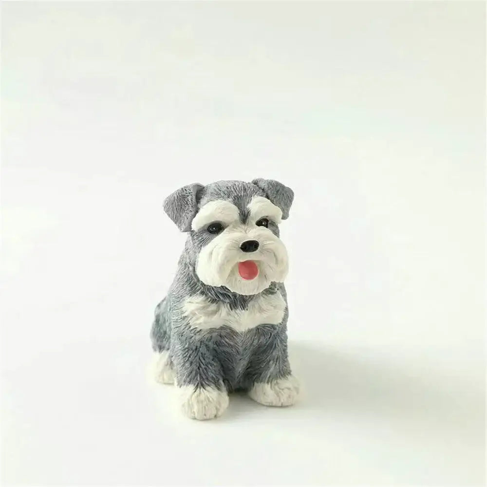 A lifelike black and white resin decorbites dog sculpture of a sitting miniature schnauzer with glossy finish