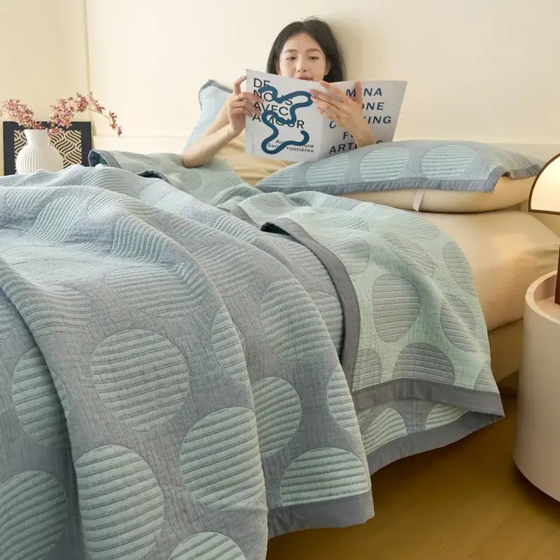 Light blue and gray decorbites cotton summer cool quilt with large circular motifs and gray border towel blanket