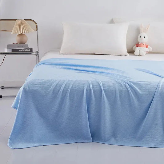 Light blue bamboo fiber summer quilt with diamond grid texture draped over a bed for decorbites bamboo fiber use