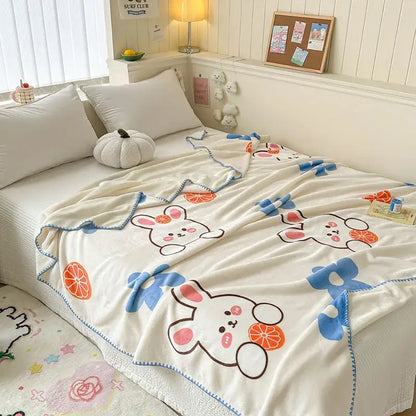 Cream-colored plush milk velvet blanket with cute bunnies, citrus slices, blue stitched borders for cozy decorbites cozy milk use