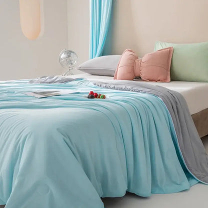 Light blue quilted cool fiber summer blanket with a soft plush texture and subtle gray trim by decorbites cool fiber