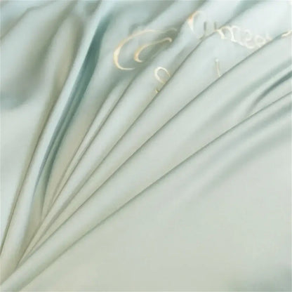 Light blue embroidered egyptian cotton bedding sets featuring soft pale green satin fabric with gold cursive lettering