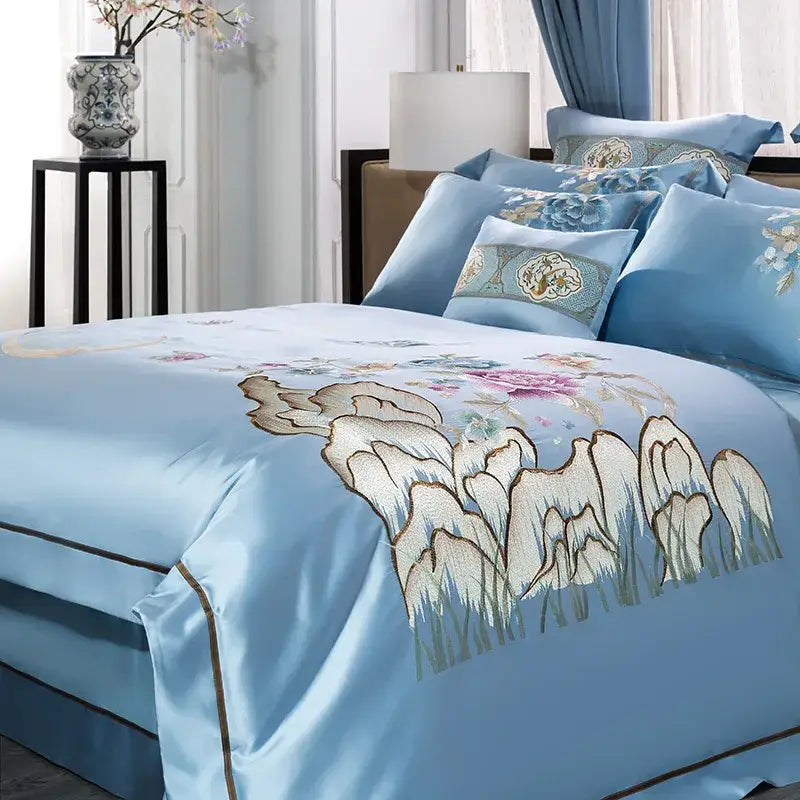 Light blue satin bedding set with intricate cream pink and gold floral and mountain 200s cotton embroidery details