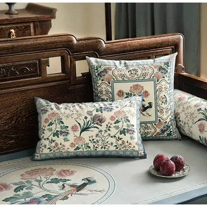Cream-colored pillow cover with intricate floral and bird motifs in soft pinks and blues for flower fragrance decor