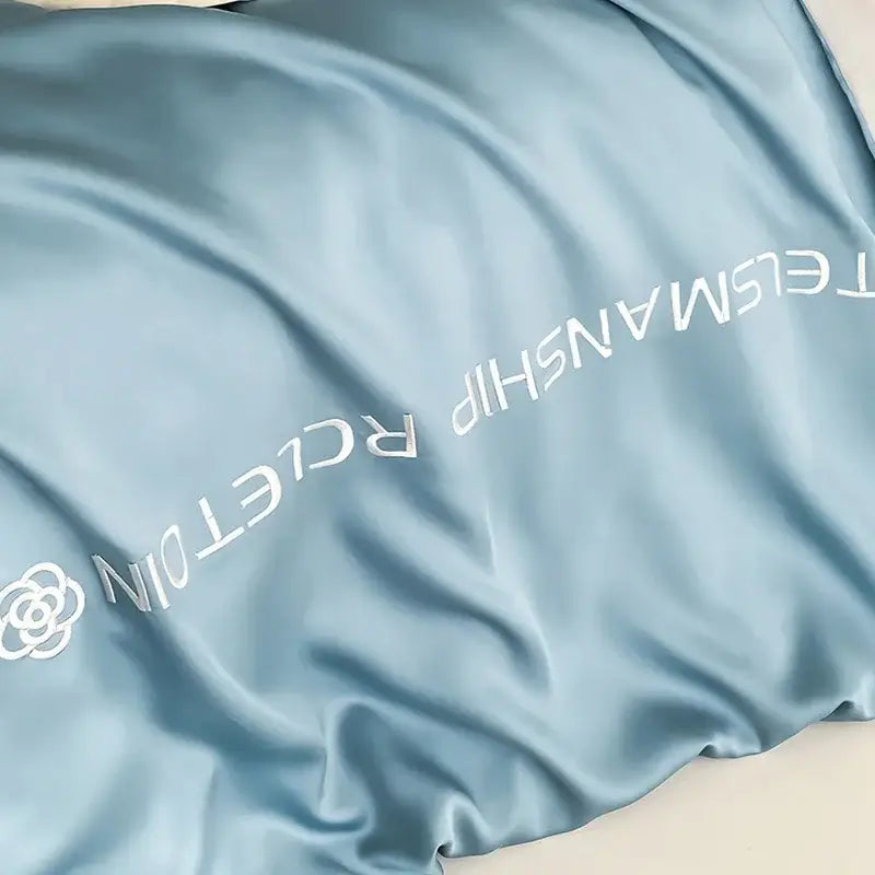 Light blue satin cotton embroidery pillowcase with subtle white embroidered logo from decorbites bedding set