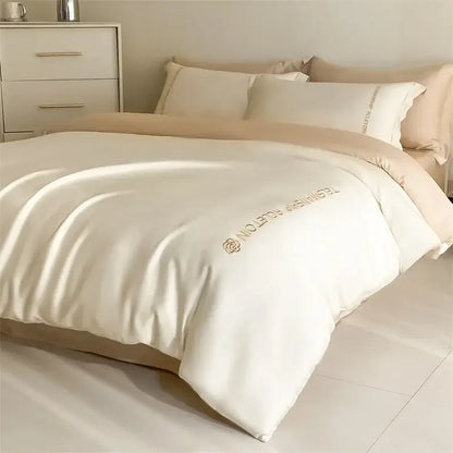 Cream-colored satin duvet cover with gold floral logo and technical edition text in light blue cotton embroidery bedding set