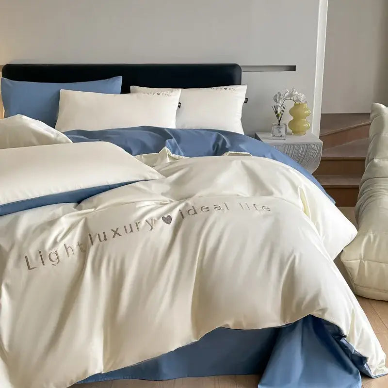 Light blue satin embroidery bedding set featuring a cream satin duvet cover with subtle light luxury embroidery in gray thread