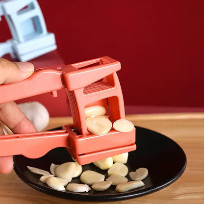 Orange plastic garlic press slicer with ridged crushing plates and handheld lever mechanism for kitchen use