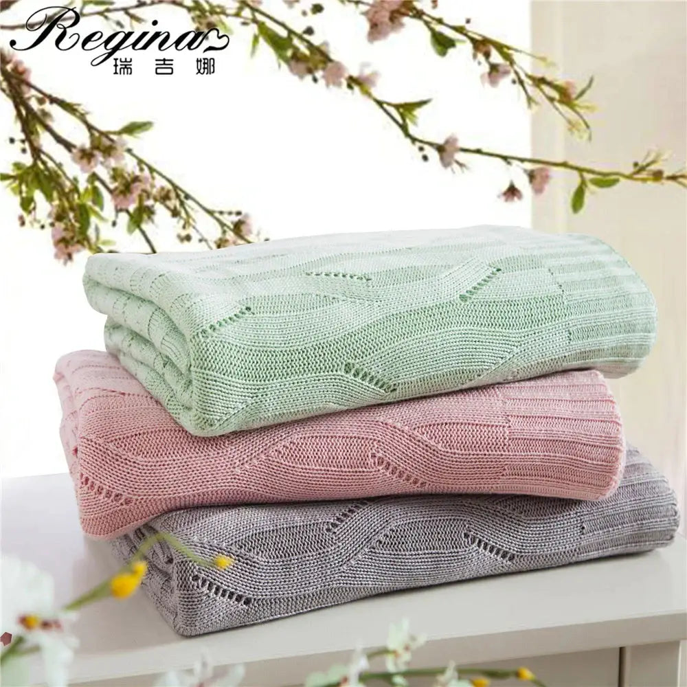 Stacked bamboo knitted cooling blankets in mint green dusty rose and gray with cable knit pattern for decorbites cooling blanket