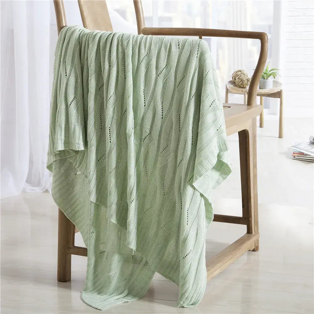 Light green bamboo knitted cooling blanket with soft textured wavy pattern and delicate openwork details by decorbites
