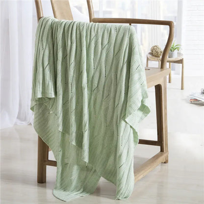 Light green bamboo knitted cooling blanket with soft textured wavy pattern and delicate openwork details by decorbites