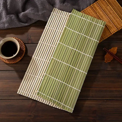 Two bamboo sushi rolling mats in natural beige and light green with white bindings in a rolling mat set for diy kitchen use