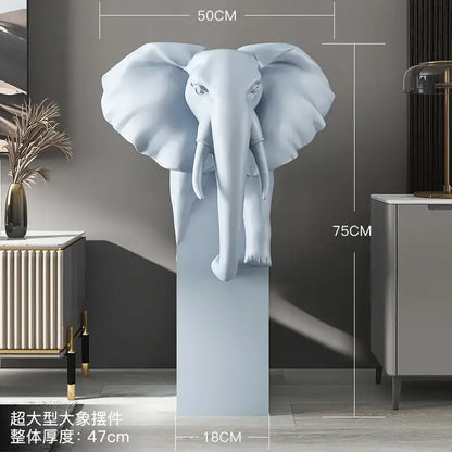 A sleek light blue elephant ornament with detailed features and smooth finish on a matching pedestal by decorbites