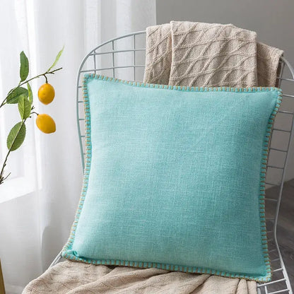 A soft mint green linen fringe cushion cover with textured, slightly frayed edge for neutral tones living room decor
