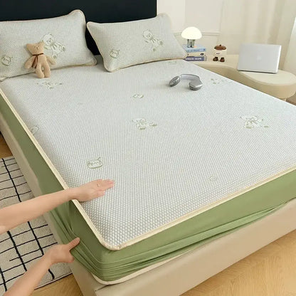 Light green textured cooling mat with subtle bear jacquard embroidery and soft beige border for bedroom use