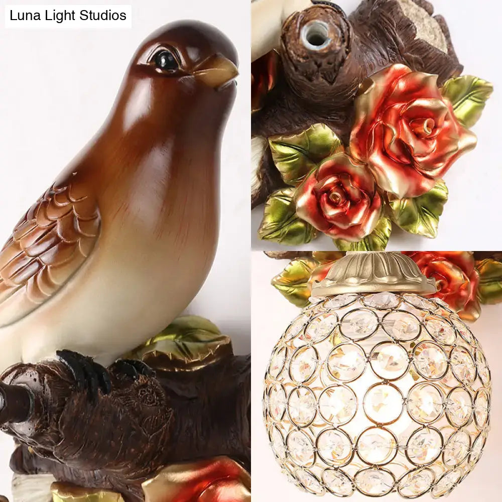 Lodge brown and cream bird wall sconce with glossy resin body and ornate crystal global shade for bedroom use