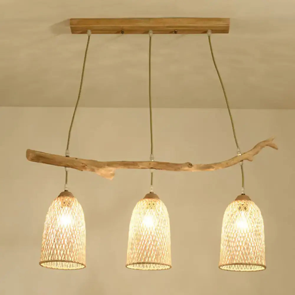 Lodge style wood pendant light featuring natural wood branch and three woven rattan shades for dining room