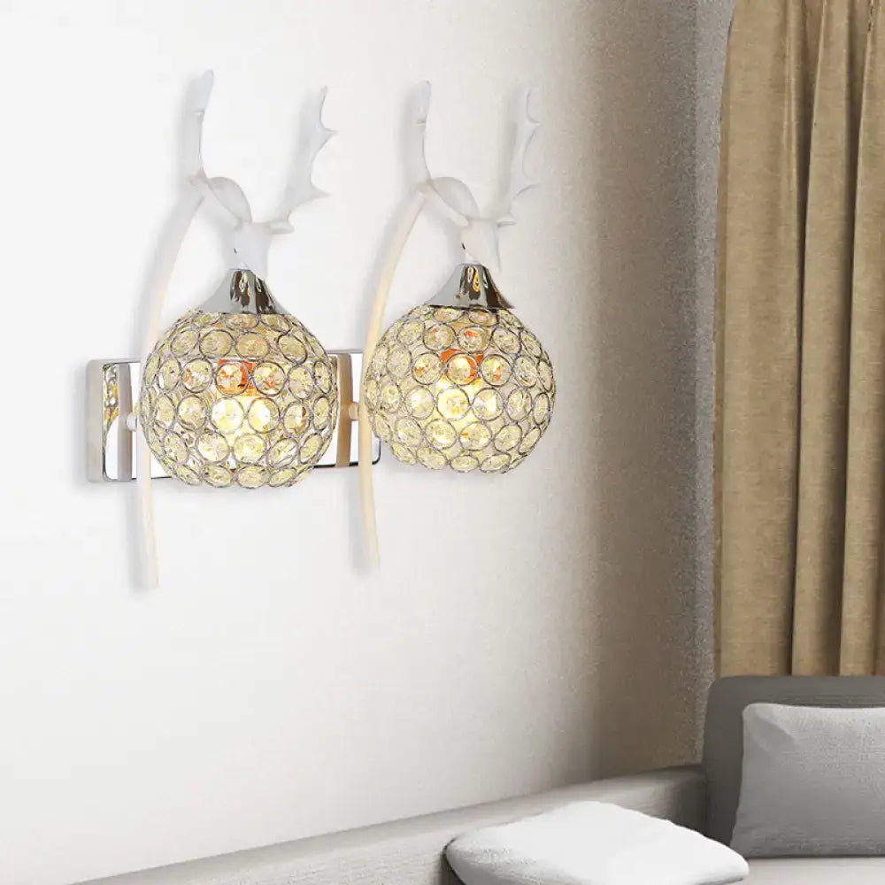 A pair of lodge white and chrome deer wall sconces with crystal dome shade and white antler wall light fixtures