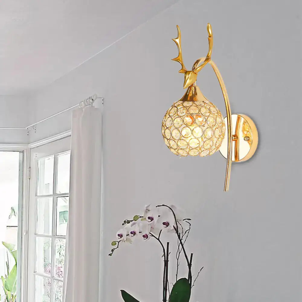 Gold-toned deer wall sconce with crystal dome shade and spherical globe suitable as a bedroom wall light