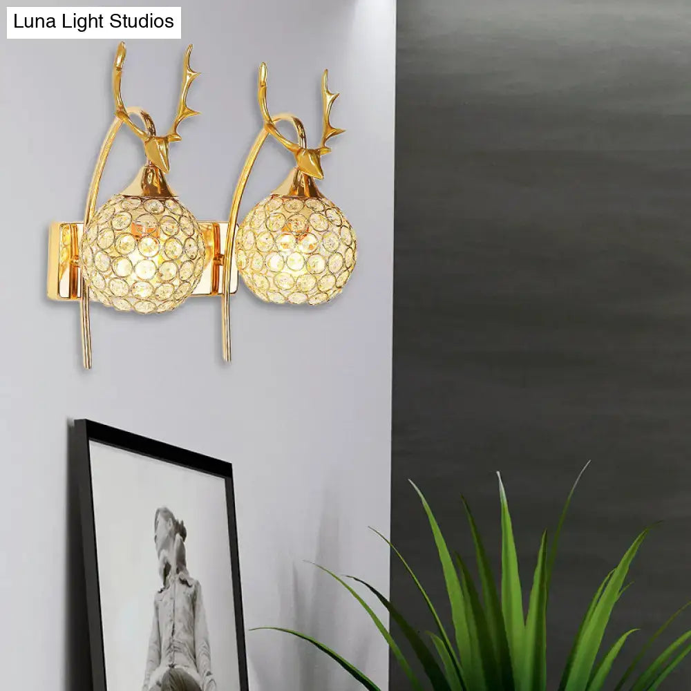 Gold-toned deer wall sconce with crystal dome shade featuring spherical crystals for bedroom wall light decor