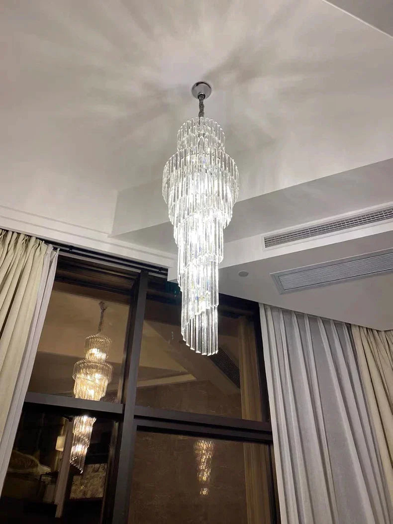 A modern long crystal staircase gold chandelier with cascading glass prisms for luxury hotel hall and villa decor