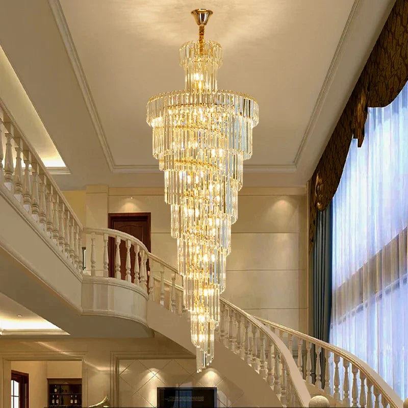 A multi-tiered crystal staircase gold chandelier with clear crystals hangs in a hotel hall for luxury home decor