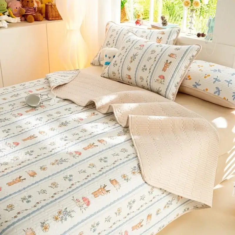Beige quilted mattress mat with decorbites cartoon pattern of deer and floral motifs in muted blues and browns cotton