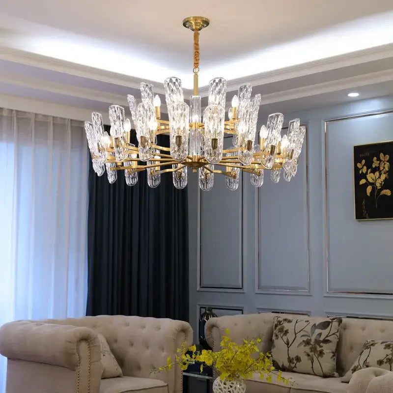 Luxe gold glass led ceiling chandelier with faceted crystal droplets and illuminated bulbs for living room use