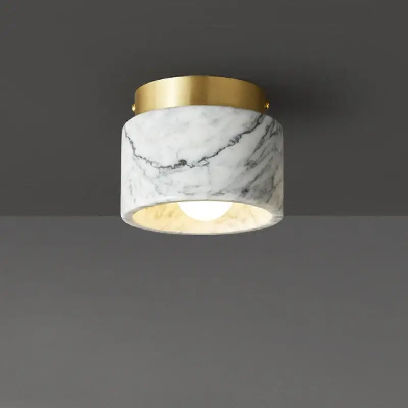A marble downlight with a white green white marble body and polished gold rim for luxe living room decorbites green white