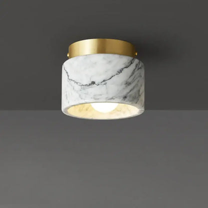 A marble downlight with a white green white marble body and polished gold rim for luxe living room decorbites green white