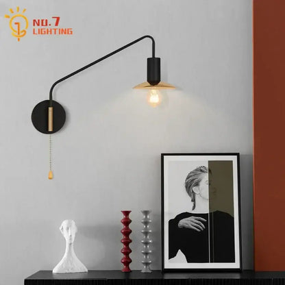 Luxury black and brass industrial wall lamp with swing arm and exposed filament bulb decorbites black gold style